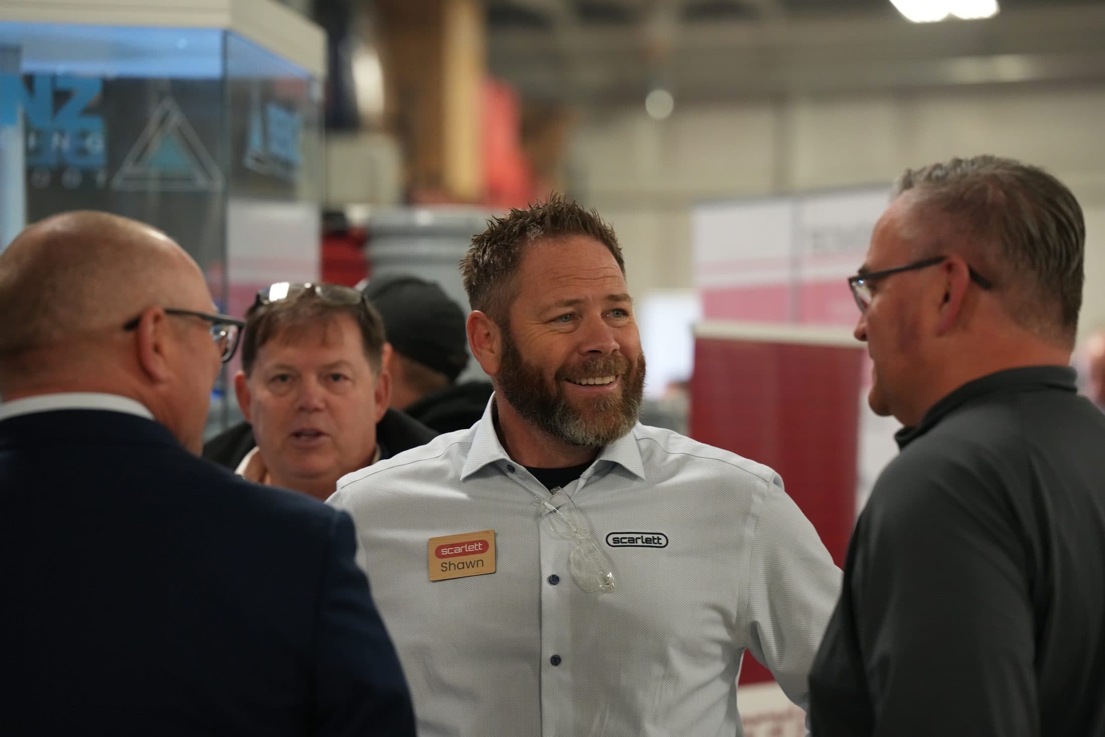 A Scarlett team member talking with customers at a machinery show