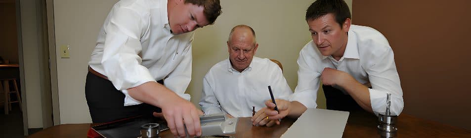 James Scarlett, Jim Scarlett, and Chris Timmer working at a desk